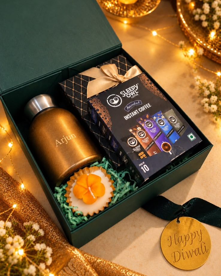 Evergreen: deep green box with a name-engraved steel bottle, Sleepy Owl instant coffee, chocolates, a flower candle and a gold Happy Diwali tag