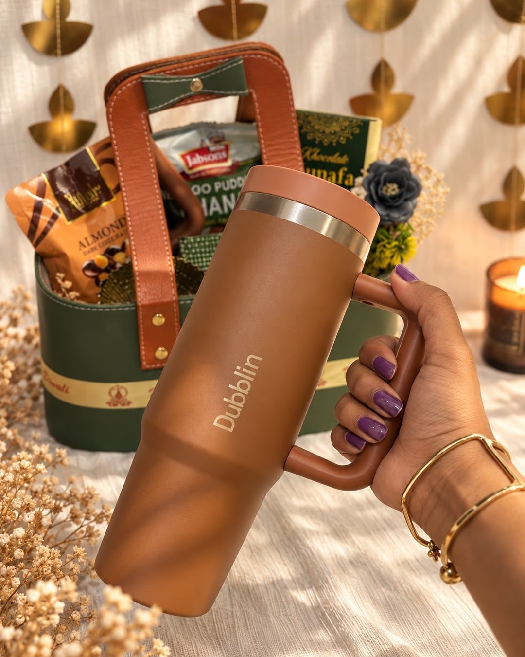 Olive & Amber: an olive leather basket with tan handles, filled with a tumbler, chocolate almonds, pudina chana and kunafa